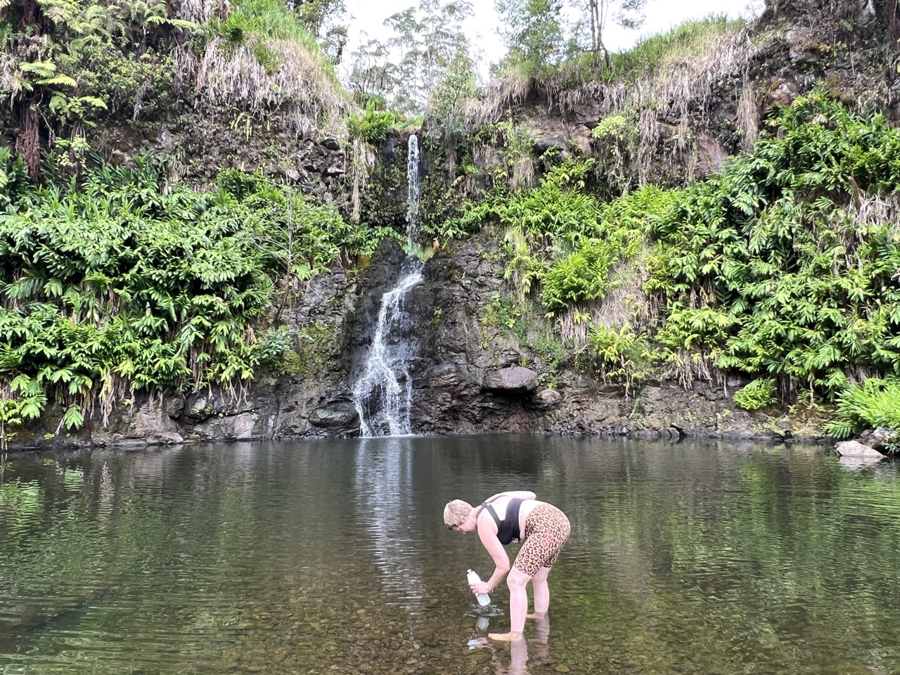 The writer filling her LARQ bottle from the water at a natural source.