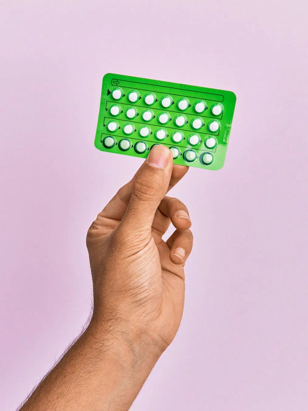A hand holds a blister pack of birth control pills from GoodRx Care