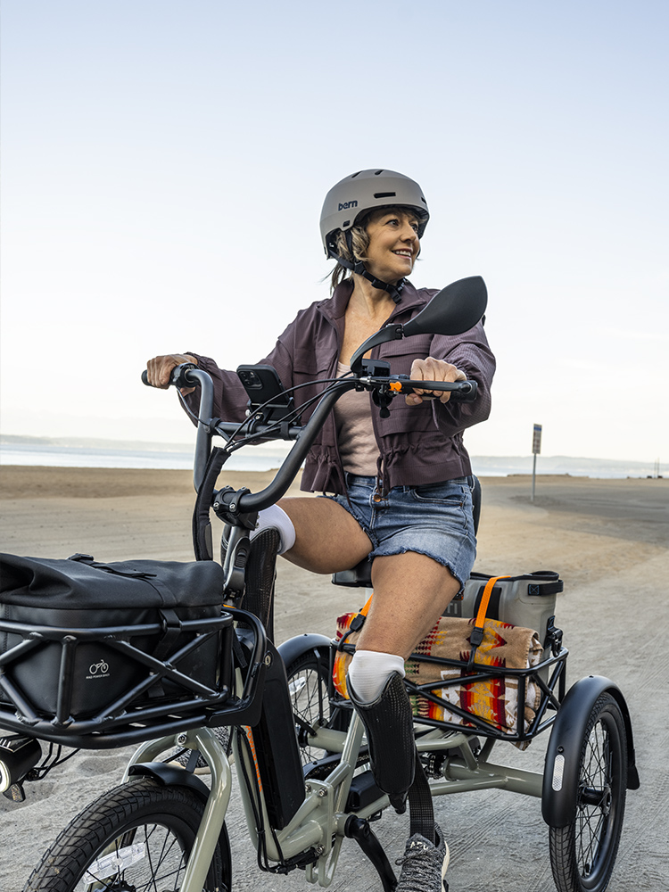 A model on a Rad Power E-Tricycle with cargo in the front and back.