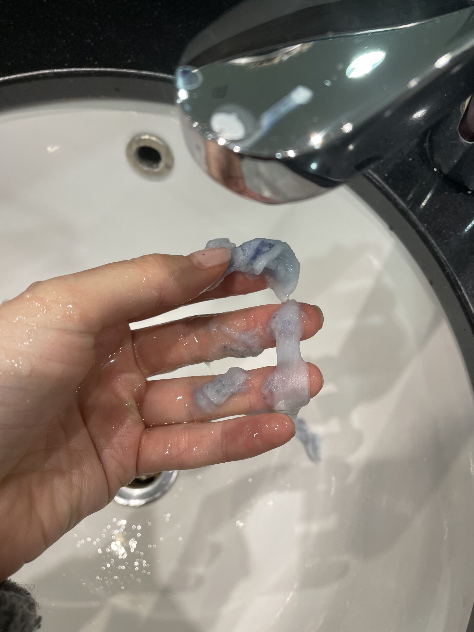 The author rinsing the tampon wrapper to demonstrate how it dissolves