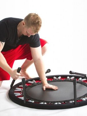 A model folding up a rebounder trampoline from Reboundair
