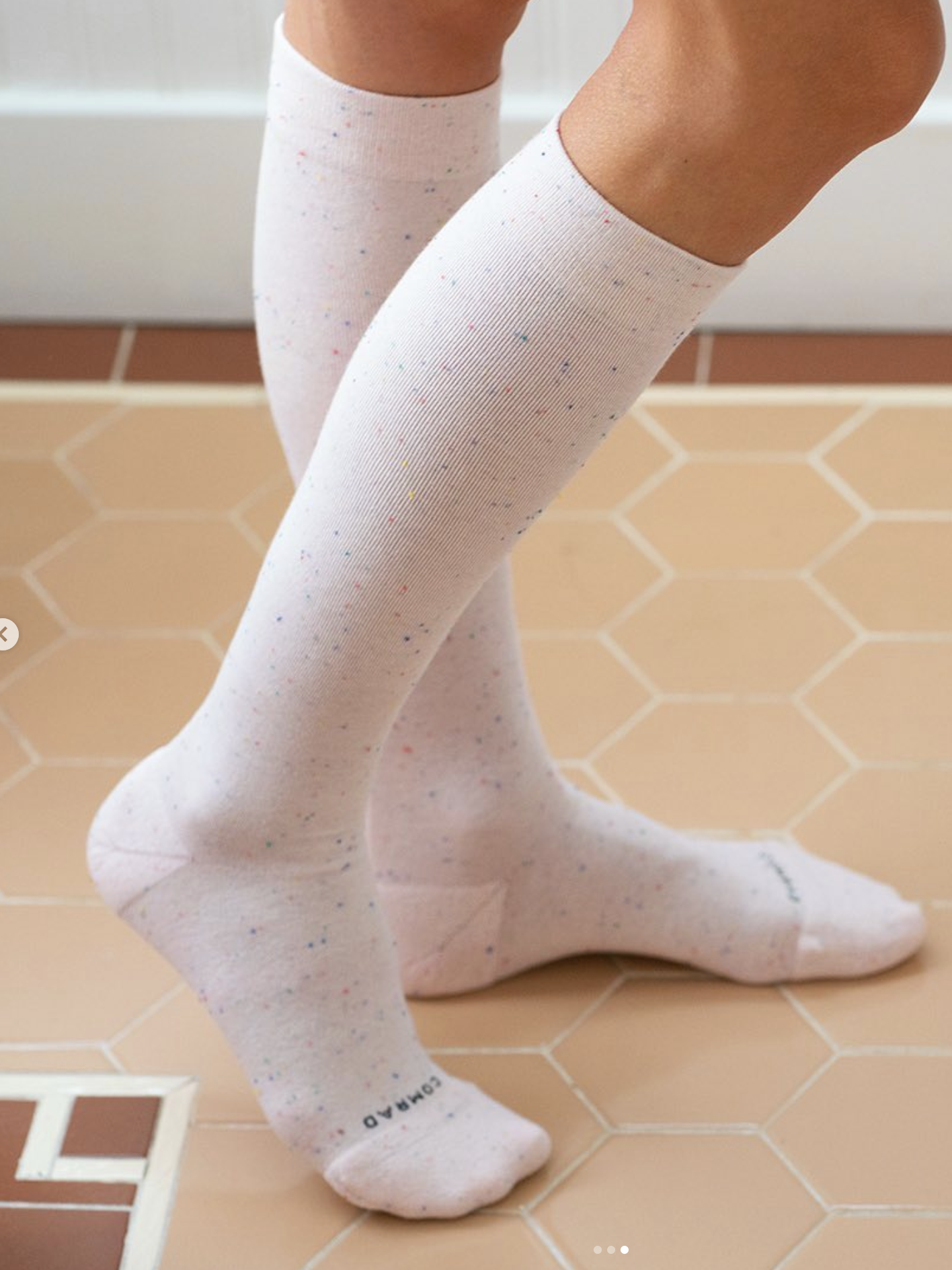Close up of a person wearing Comrad knee high compression socks in a sprinkle pattern.
