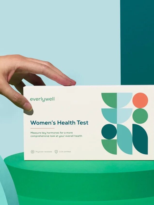 A hand holding up a women's health test.