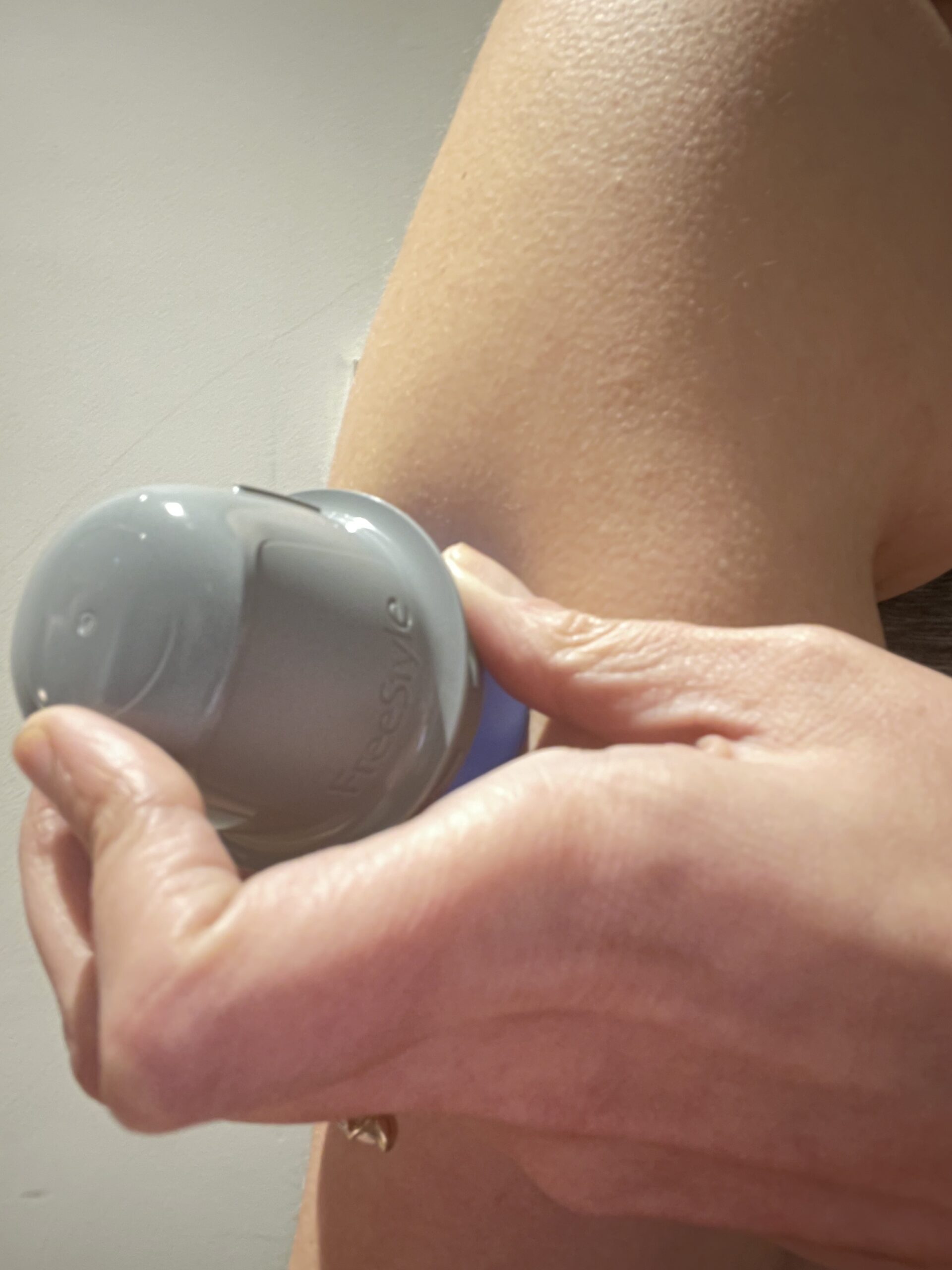 Applying sunscreen from a bottle outdoors.