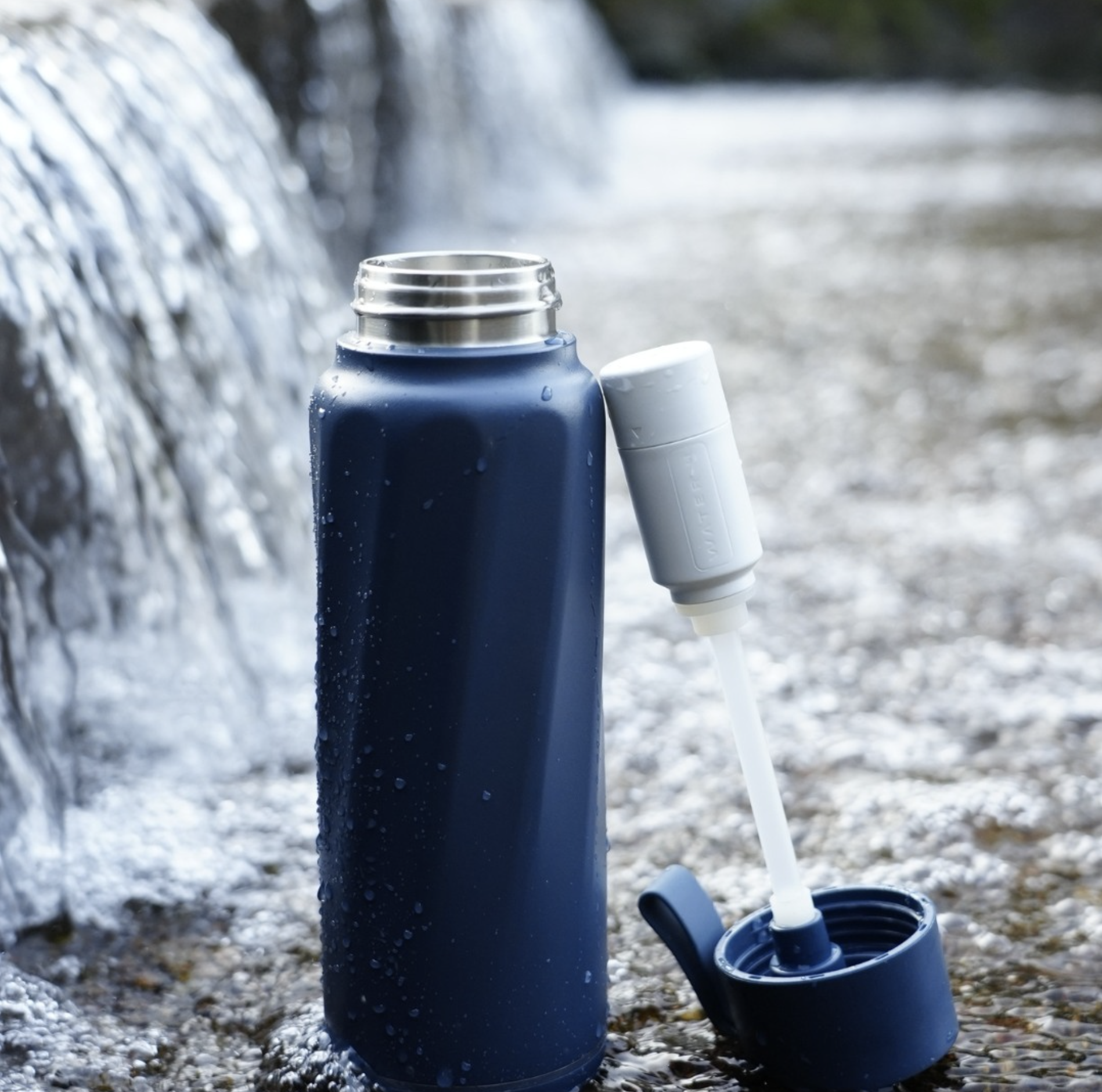 A water bottle sitting on rock outside.