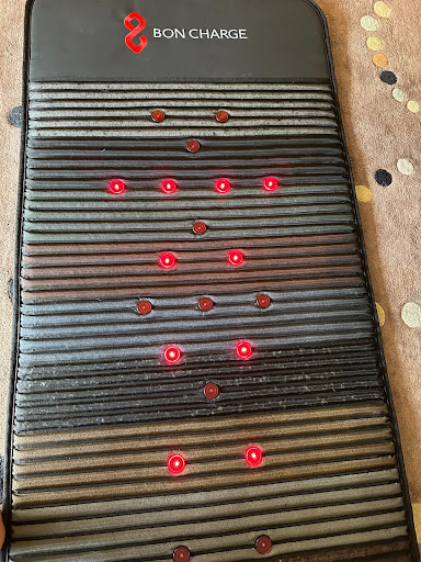 An infrared sauna mat with glowing red lights turned on.