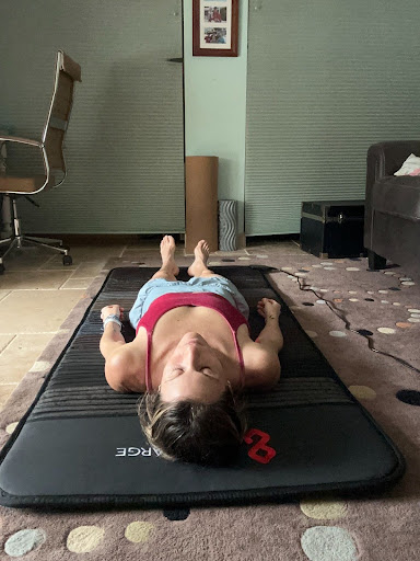 Woman resting on a workout mat indoors.