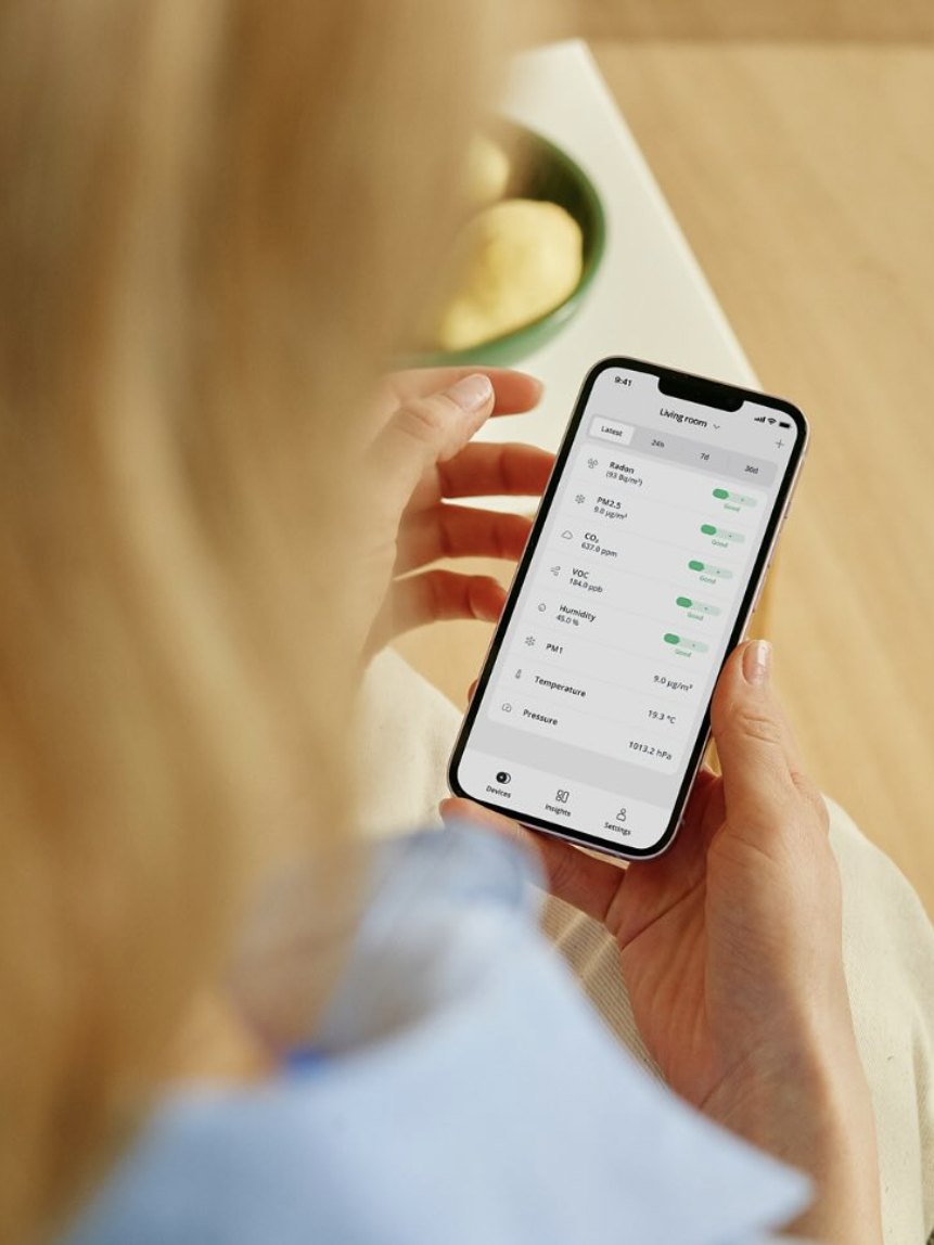 A person holding a smartphone displays a health app tracking steps, heart rate, and other metrics.