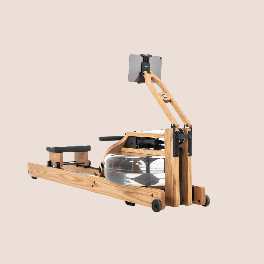 A wooden water rowing machine with a padded seat, footrests, a water tank for resistance, and a mounted holder for a tablet or smartphone—perfect for pairing with massage guns to soothe muscles after an intense workout, set against a plain beige background.