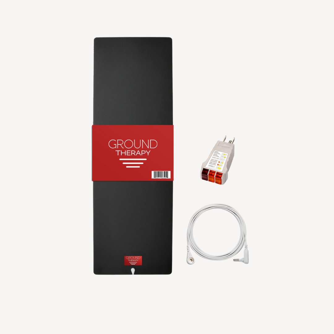 Black grounding therapy mat with a red label, displayed next to a white outlet tester and coiled white grounding cord—perfect for use with massage guns to enhance your relaxation routine. All items shown on a clean white background.