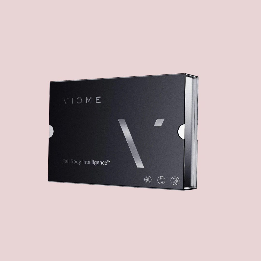 A black Viome Full Body Intelligence kit box is shown against a plain light pink background, emphasizing wellness tools like massage guns designed to support your health journey.