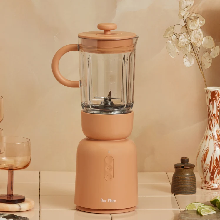 Peach-colored personal blender on a tiled countertop.